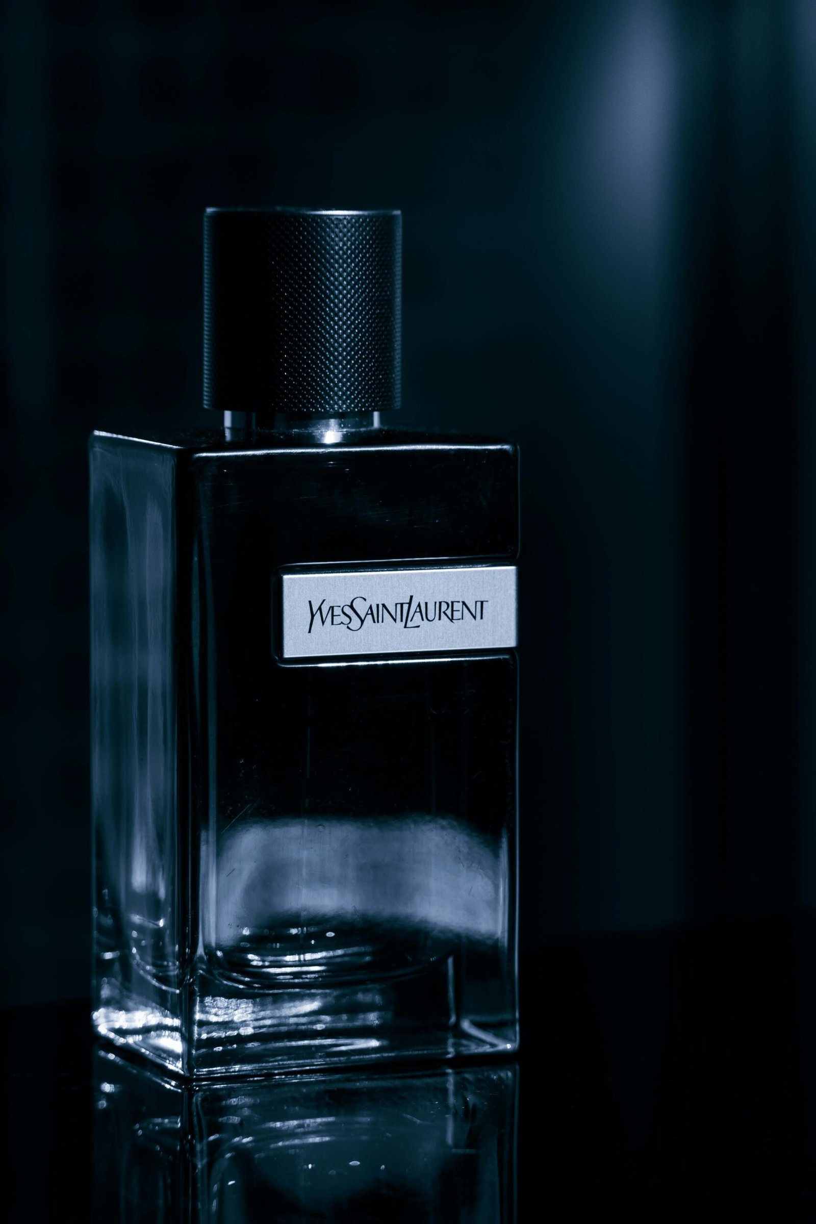 Close-up of an Yves Saint Laurent perfume bottle with a sleek black background.