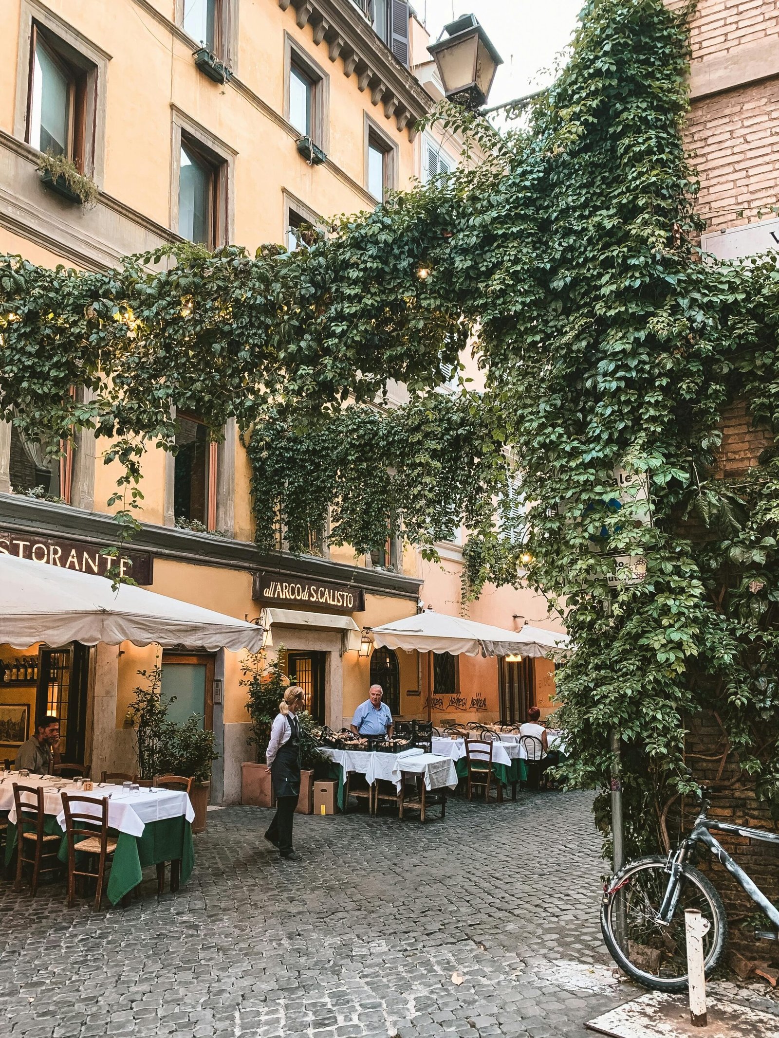 Charming cafe with ivy-covered facade and outdoor seating in Rome, Italy.