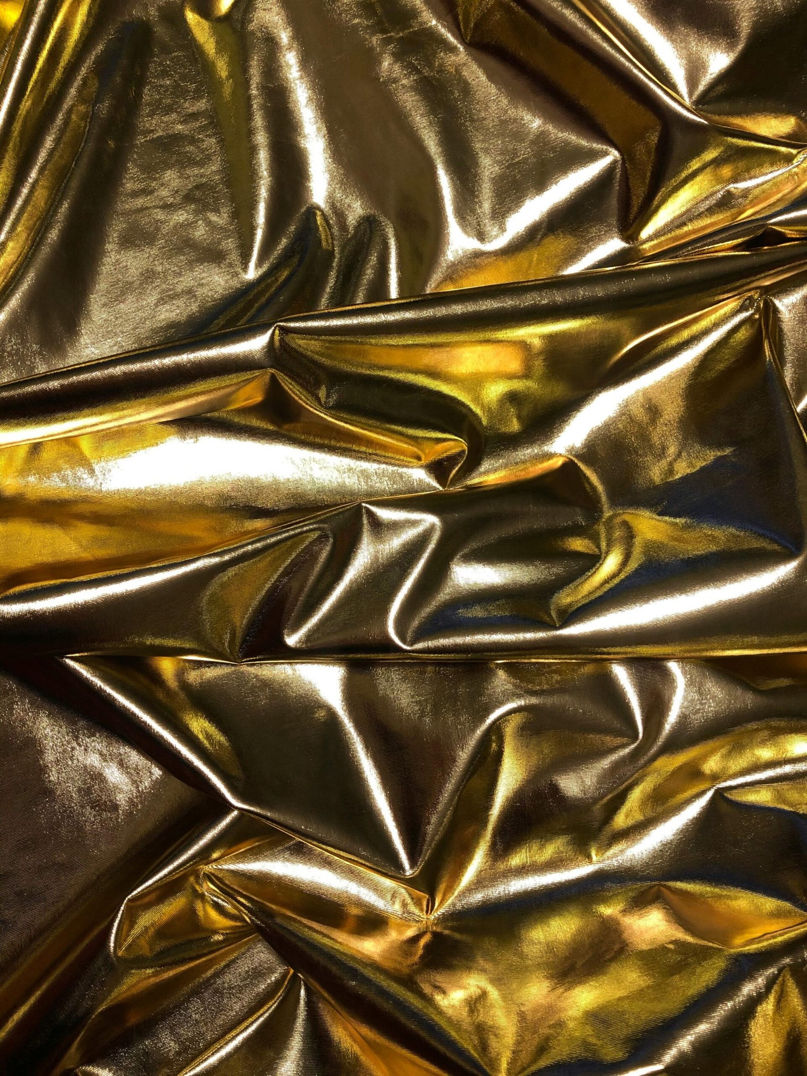 Crinkled gold metallic texture creating a luxurious and vibrant background.